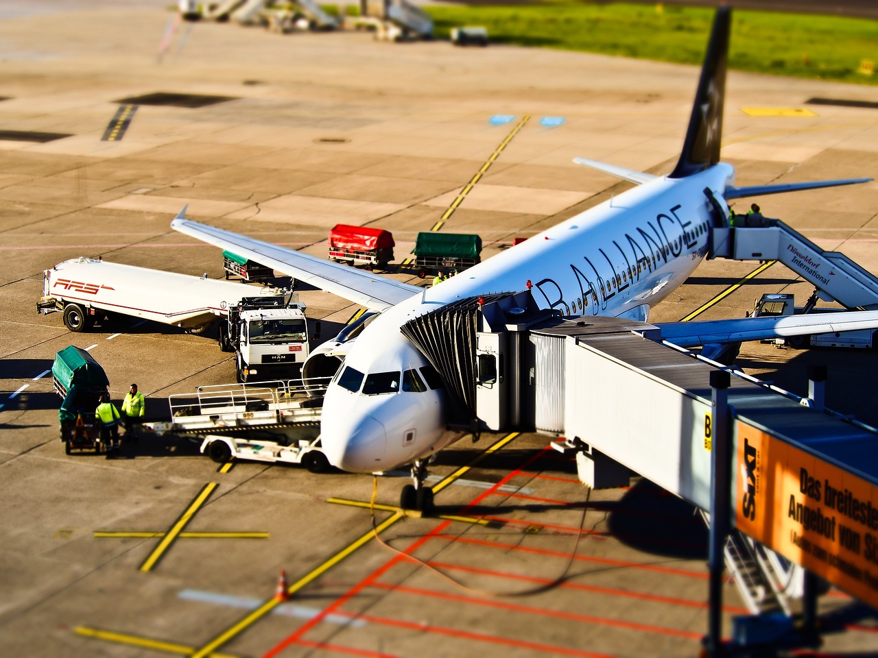 Airplane parked at an airport gate with ground equipment.