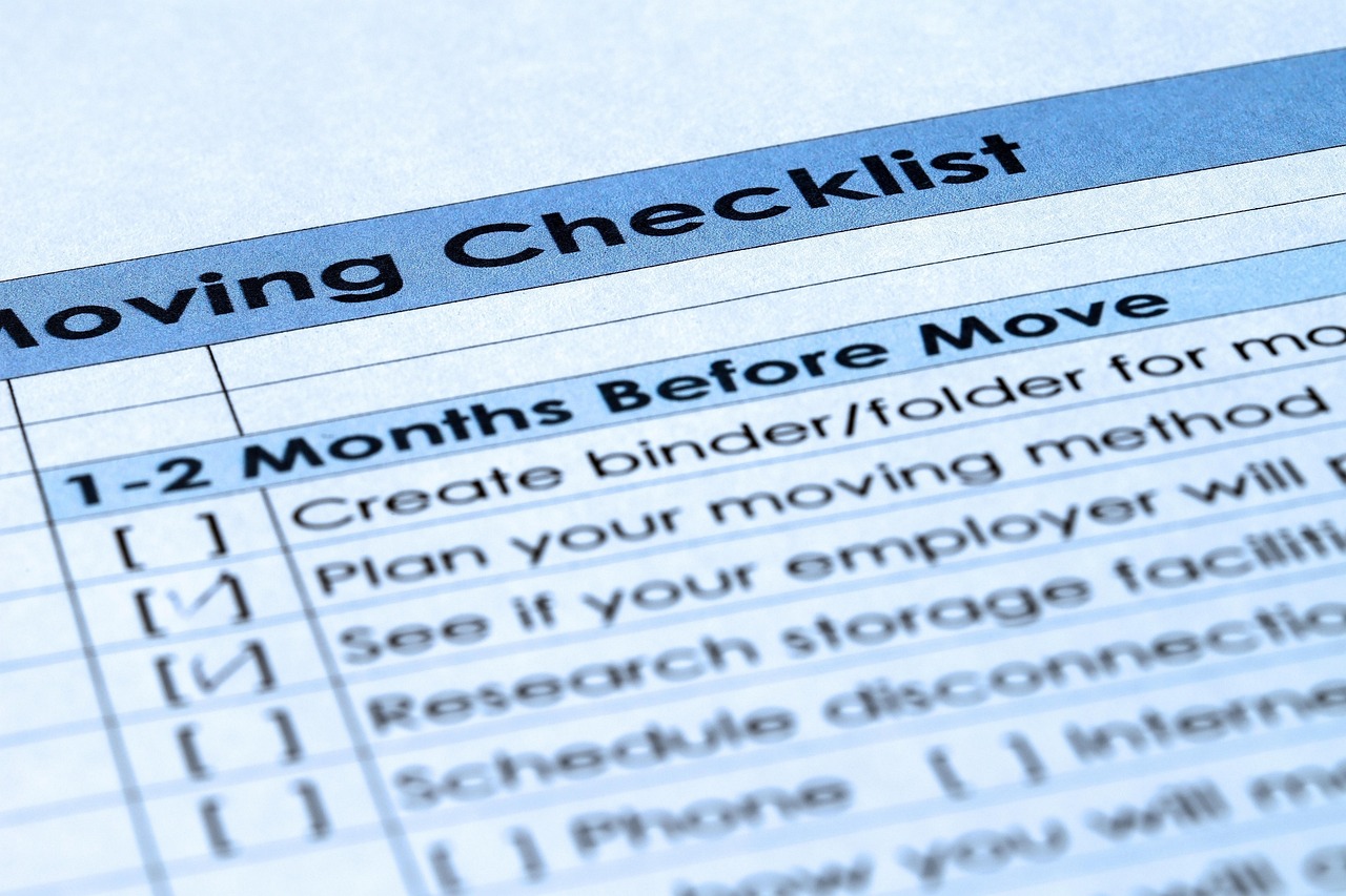 Close-up of a paper document showing a &ldquo;Moving Checklist&rdquo; with some items checked off.