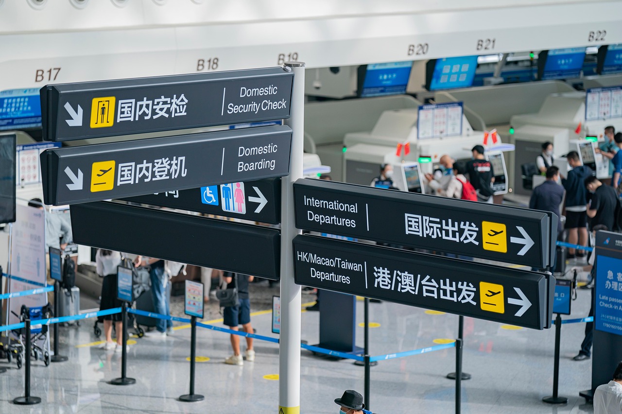 An airport signpost showing directions for Domestic Security Check, Domestic Boarding, and International Departures.