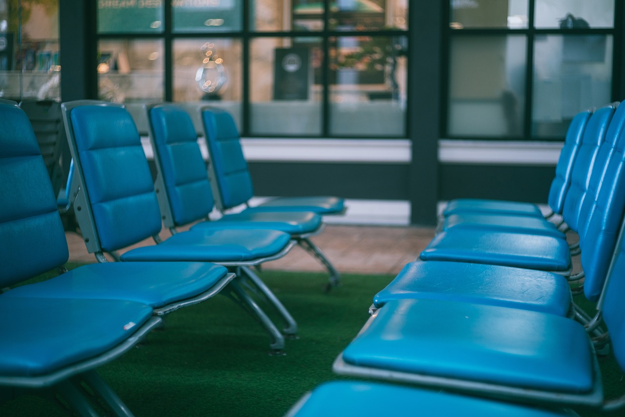 Rows of empty blue chairs in a waiting area.