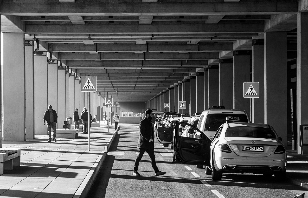 Air Canada check-in with an eTA: man walking towards a taxi at a taxi rank under a concrete structure
