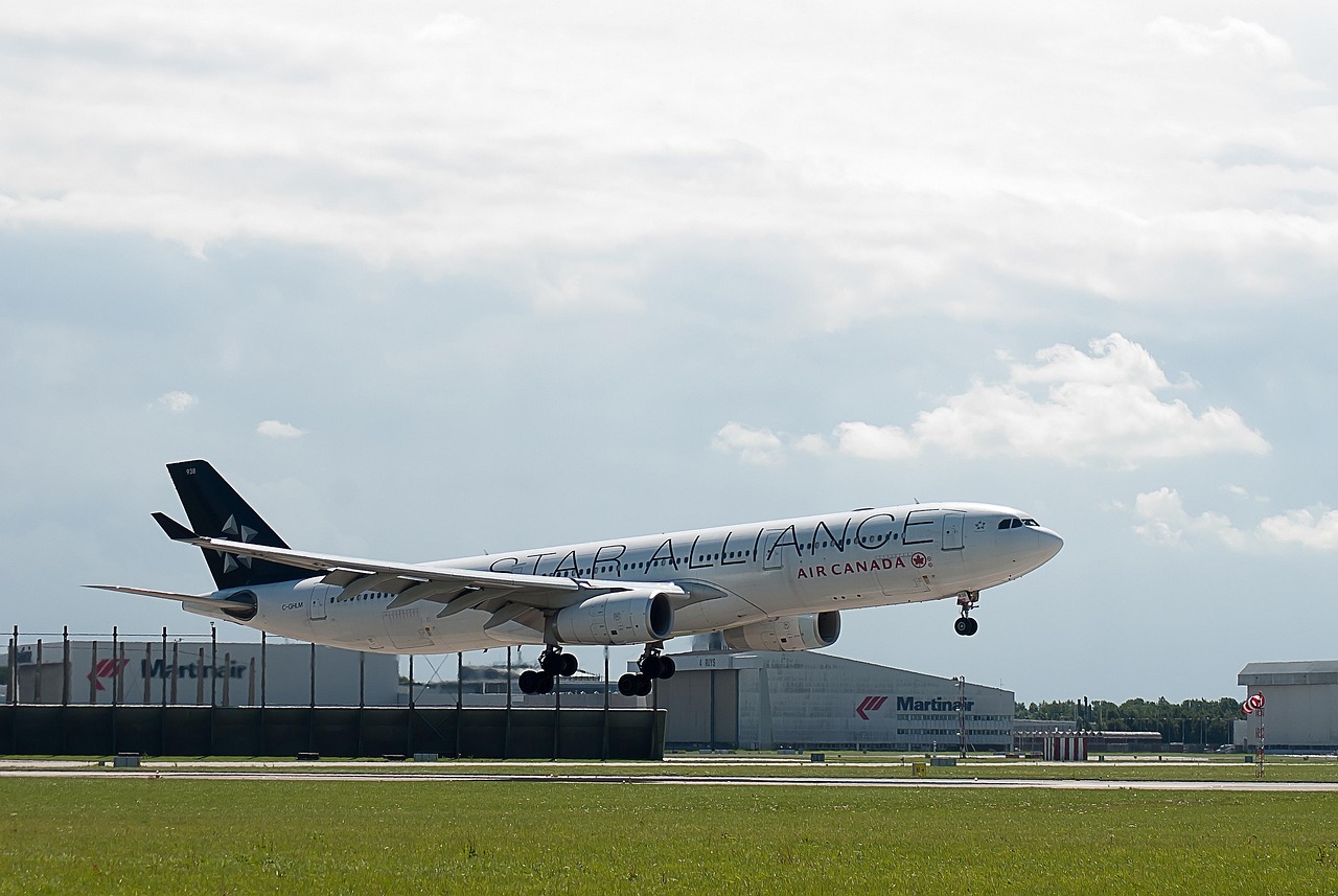 An Air Canada airplane taking off from an airport runway under a cloudy sky.