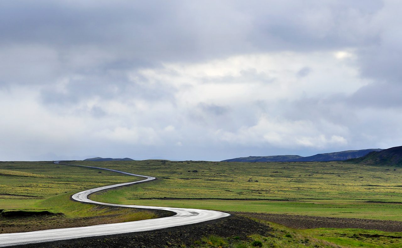 Do US Citizens Need a Canada eTA? Entering Canada From the US: winding road across open green countryside under a cloudy sky
