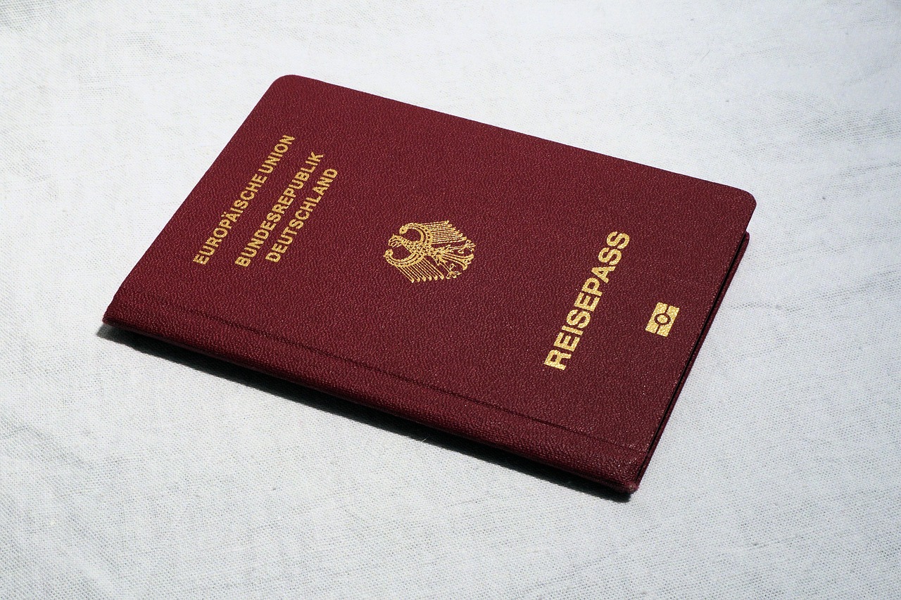A dark red German passport on a light, textured surface.